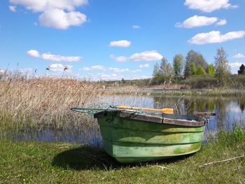 Boat moored on field against sky