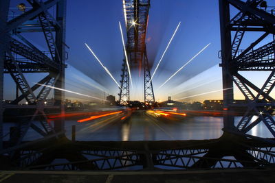 Illuminated bridge against sky at night