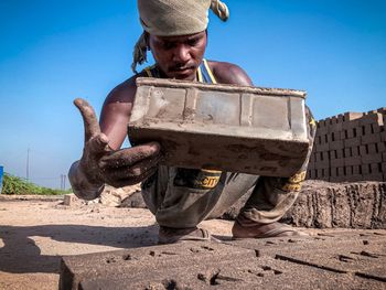 Man holding hat against clear sky