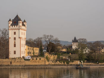 River by buildings against clear sky