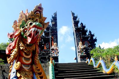Low angle view of statues on building against sky