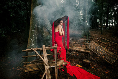 Woman sitting on wood in forest