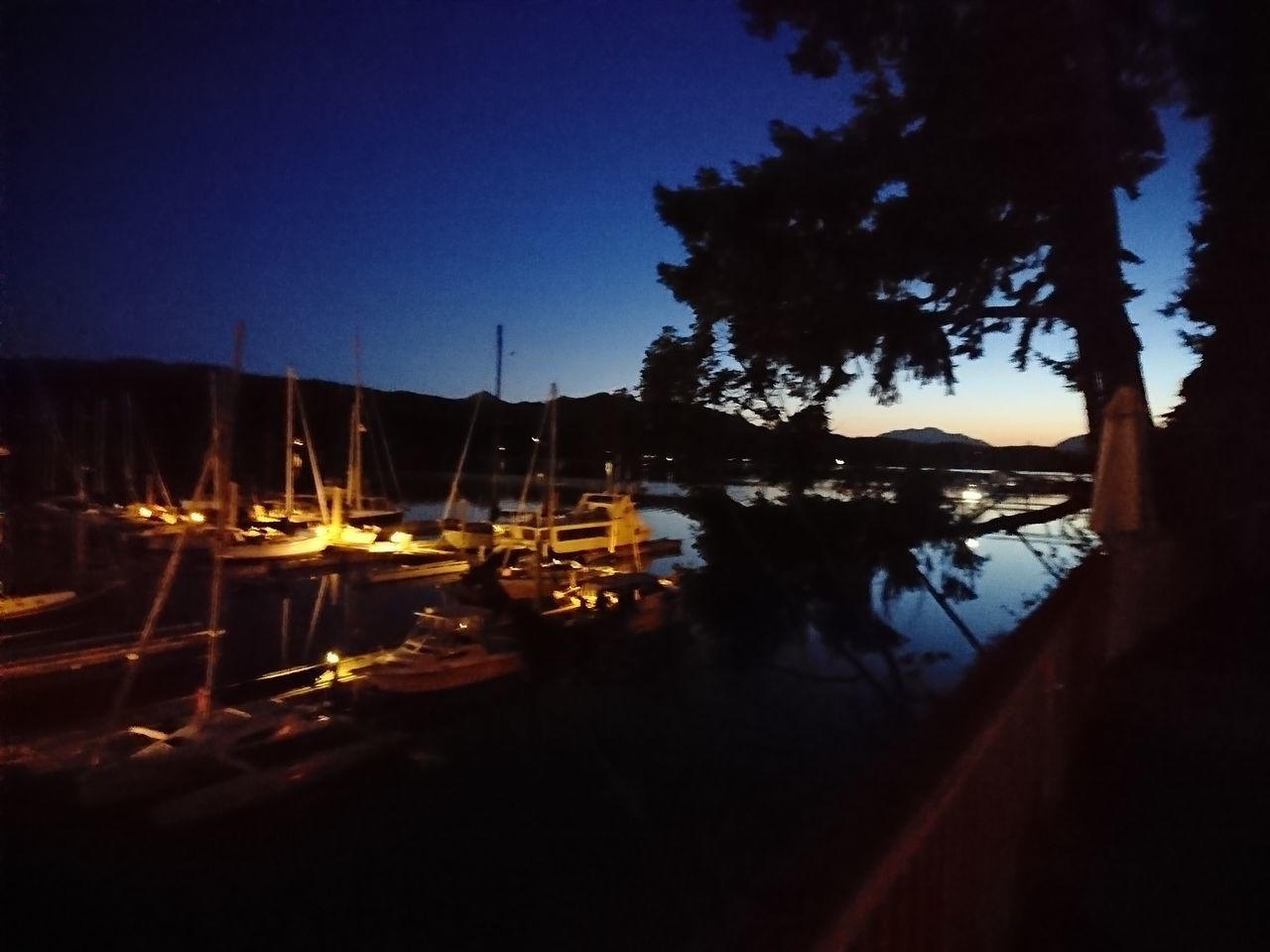 SILHOUETTE OF BOATS MOORED AT HARBOR