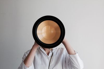 Close-up of hand holding camera against white background