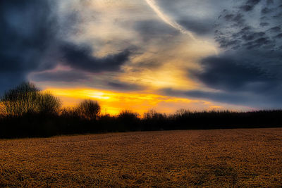 Scenic view of field against sky at sunset
