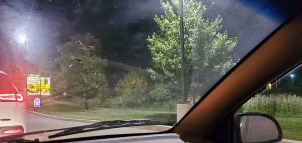 Car on street seen through wet window