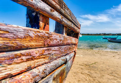 Abandoned boat on beach against sky