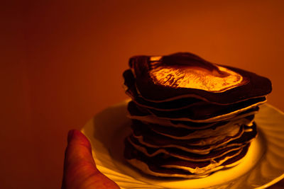 Cropped hand holding plate with pancakes