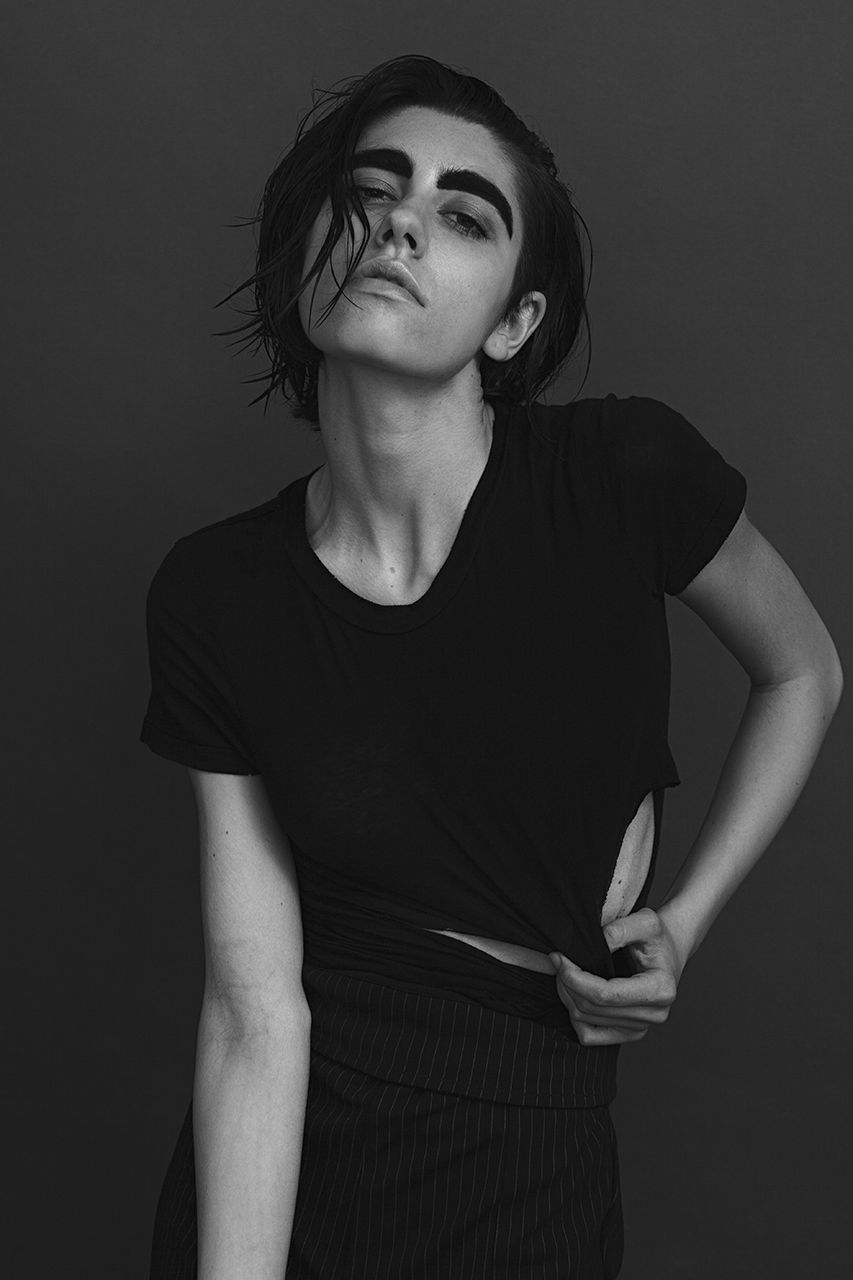 PORTRAIT OF A YOUNG WOMAN AGAINST GRAY BACKGROUND