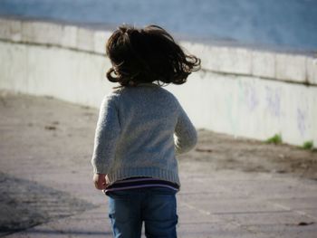 Rear view of girl running on road