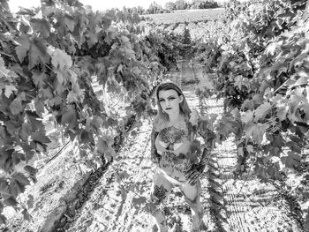 Portrait of woman standing by plants