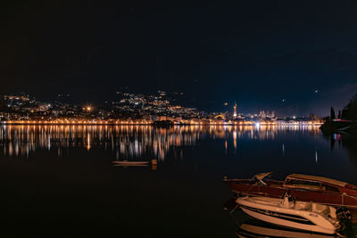 Boats moored in harbor at night