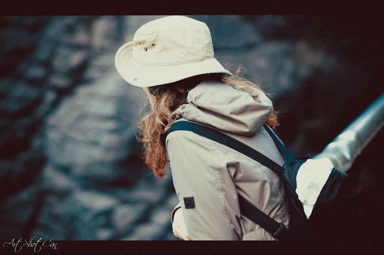 SIDE VIEW OF WOMAN WEARING HAT AGAINST BLURRED BACKGROUND