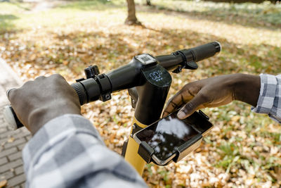 Man using mobile app on electric push scooter