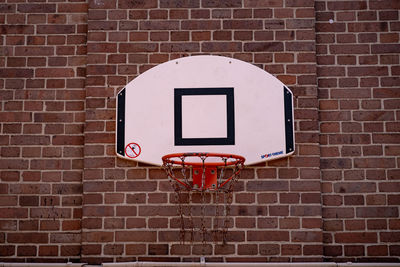 Low angle view of basketball hoop against brick wall