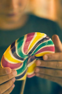 Close-up of hand holding colorful lollipop