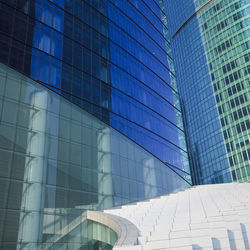 Low angle view of glass building against sky