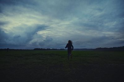 Silhouette of man standing on field against sky