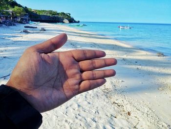 Cropped hand of man at beach