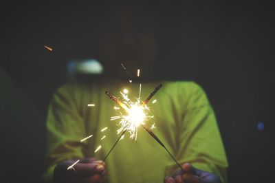 Close-up of hand holding sparkler at night