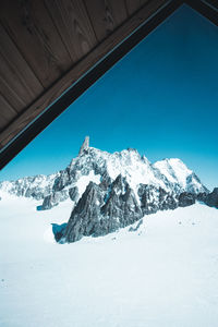 Scenic view of snowcapped mountains against clear blue sky