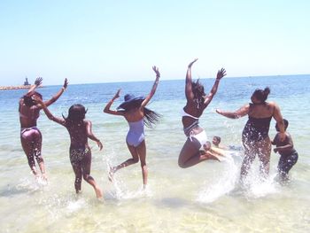 Group of people at beach against sky