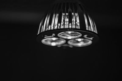 Low angle view of illuminated lamp against black background