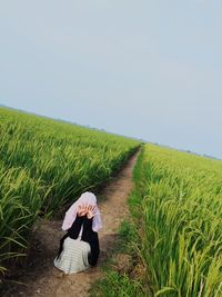 Rear view of woman on field against sky