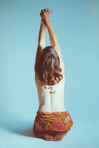 Rear view of woman standing against white background