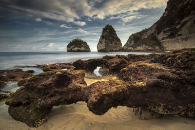 Rocks on sea shore against sky