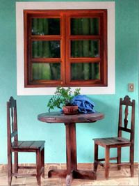 Empty chairs and table in front of wall