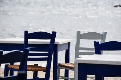 Table and chairs against sea