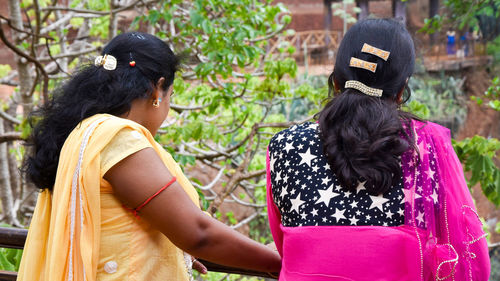 Rear view of women standing outdoors