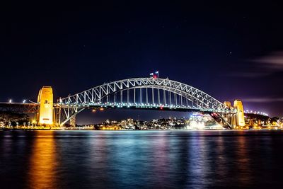 Suspension bridge over river at night