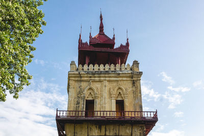 Low angle view of a leaning tower against blue sky