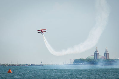 Airplane flying over sea against sky