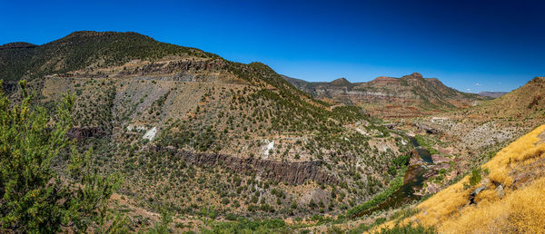 Scenic view of mountains against clear blue sky