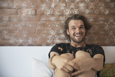 Young man sitting on his bed