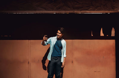 Young man standing against wall