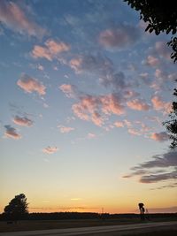 Scenic view of silhouette field against sky at sunset