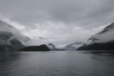 Scenic view of sea and mountains against sky