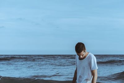 Full length of man standing at beach against sky