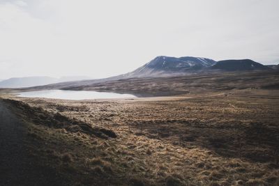 Scenic view of landscape and mountains against clear sky