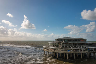 Low angle view scheveningen beach with blurred pier and ferris wheel in the background