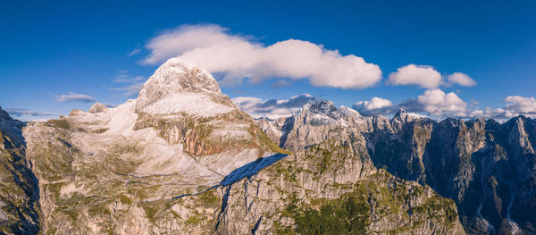 Panoramic view of the mangart mountain range in the julian alps with mountain pass road, slovenia.