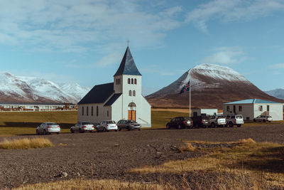 Cars on street amidst buildings against sky