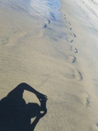 Shadow of man on sand at beach