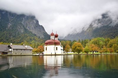 Building by lake against sky