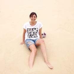 Full length of woman sitting at beach