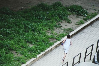 High angle view of boy jogging on footpath